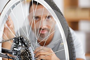 man fixing bike wheel in store photo