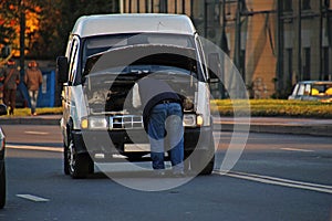 Man fixing a car on the road