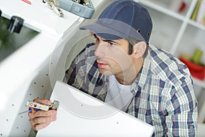 man fixing cabinet door