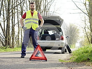 Man fixing a car problem after vehicle breakdown on the road