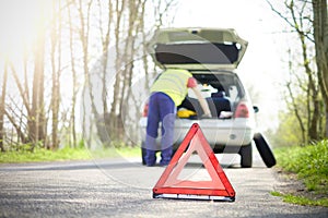 Man fixing a car problem after vehicle breakdown on the road