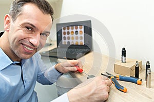 man fixing circuit board using screwdriver