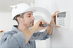 Man fixing digital thermostat