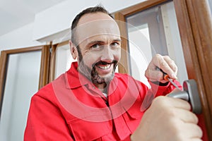 Man fixing door handle with screwdriver