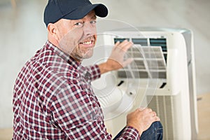 man fixing and maintaining air conditioning system