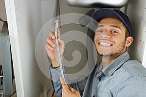 man fixing sink pipe in kitchen