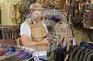 man with flak jacket in hands in airsoft market