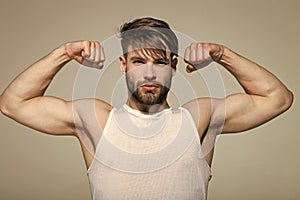 Man flex muscles, biceps, triceps on grey background