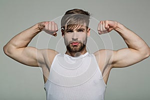 Man flex muscles, biceps, triceps on grey background