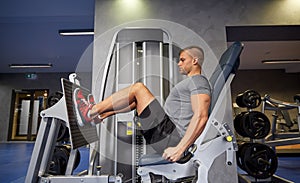 Man flexing leg muscles on gym machine