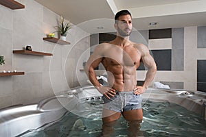 Man Flexing Muscles in Jacuzzi Spa