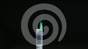 Man flicks syringe prior to drug injection, to collect and release the air out of the syringe.