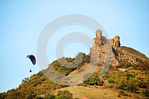 A man flies in his paraglider near Siria Medieval Fortress in Arad County, Romania.