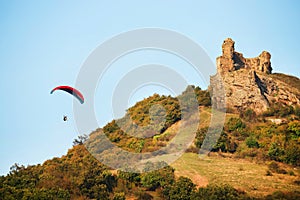 A man flies in his paraglider near Siria Medieval Fortress in Arad County, Romania.