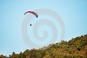 A man flies in his paraglider near Siria Medieval Fortress in Arad County, Romania. photo