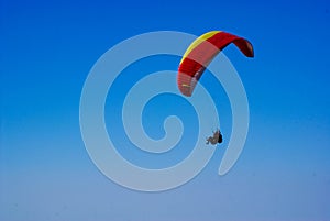 Man flies on a sports parachute against a blue sky