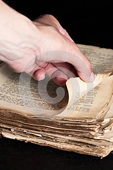 Man flips through an old copy of the Bible
