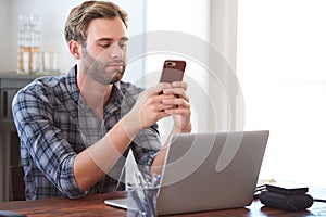 Man flirting on his phone while sitting at his desk
