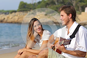 Man flirting playing guitar while a girl looks him amazed