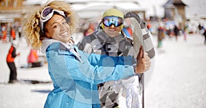 Man flirting with woman holding snowboard