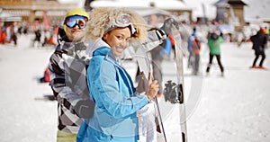 Man flirting with woman holding snowboard