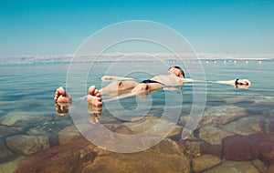 Man float meditating in water Dead Sea. Tourism recreation, healthy lifestyle concept. Copy space. Peaceful meditation