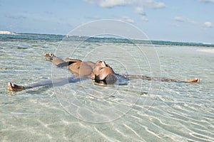 Man floating in water on the beach