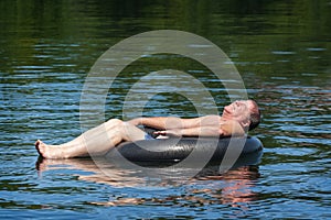 Man Floating in Water on Inner Tube