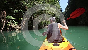 man floats kayak and looks around kayak