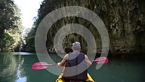 man floats kayak and looks around kayak