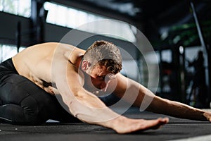 Man on the floor in the gym doing stretching after push-ups from the floor