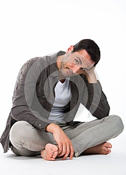 man on the floor holding head with hand