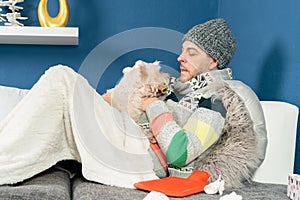 Man with flu cuddles with his dog on the couch