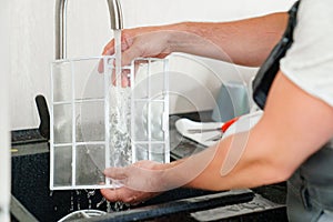 A man flushes the air cleaner filter from the air conditioner.