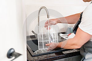 A man flushes the air cleaner filter from the air conditioner.