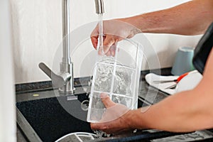 A man flushes the air cleaner filter from the air conditioner. photo