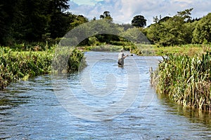 Man fly fishing casts on Irish river