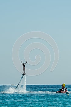 Man on flyboard above the azure sea. Water sport adventure