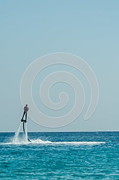 Man on flyboard above the azure sea. Water sport adventure