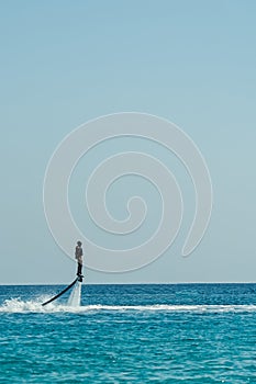 Man on flyboard above the azure sea. Water sport adventure