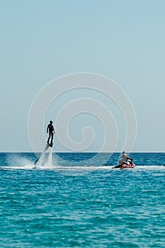 Man on flyboard above the azure sea. Water sport adventure