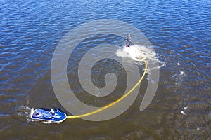 Man on the flyboard. Flyboard view from drone. Aerial view of water extreme action sport. Guy is flying at the aquatic flyboard