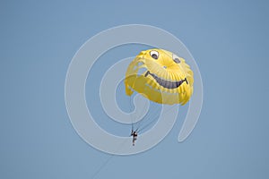 Man flying on a colored parachute at sunrise