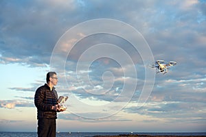 Man flying drone with remote control at the beach