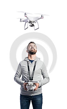 Man with flying drone. Studio shot on white background, isolated