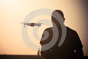 Man flying a drone at sunrise