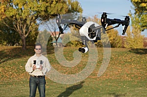 Man Flying A High-Tech Camera Drone (Fall Trees & Leaves in Background)