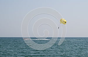 Man flying on a parachute behind above the sea photo