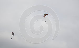 A man is flying on a paraglider in clouds and fog. Summer sports, active lifestyle