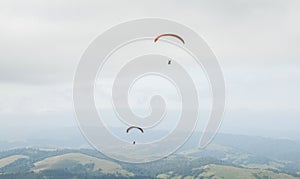 A man is flying on a paraglider in clouds and fog. Summer sports, active lifestyle